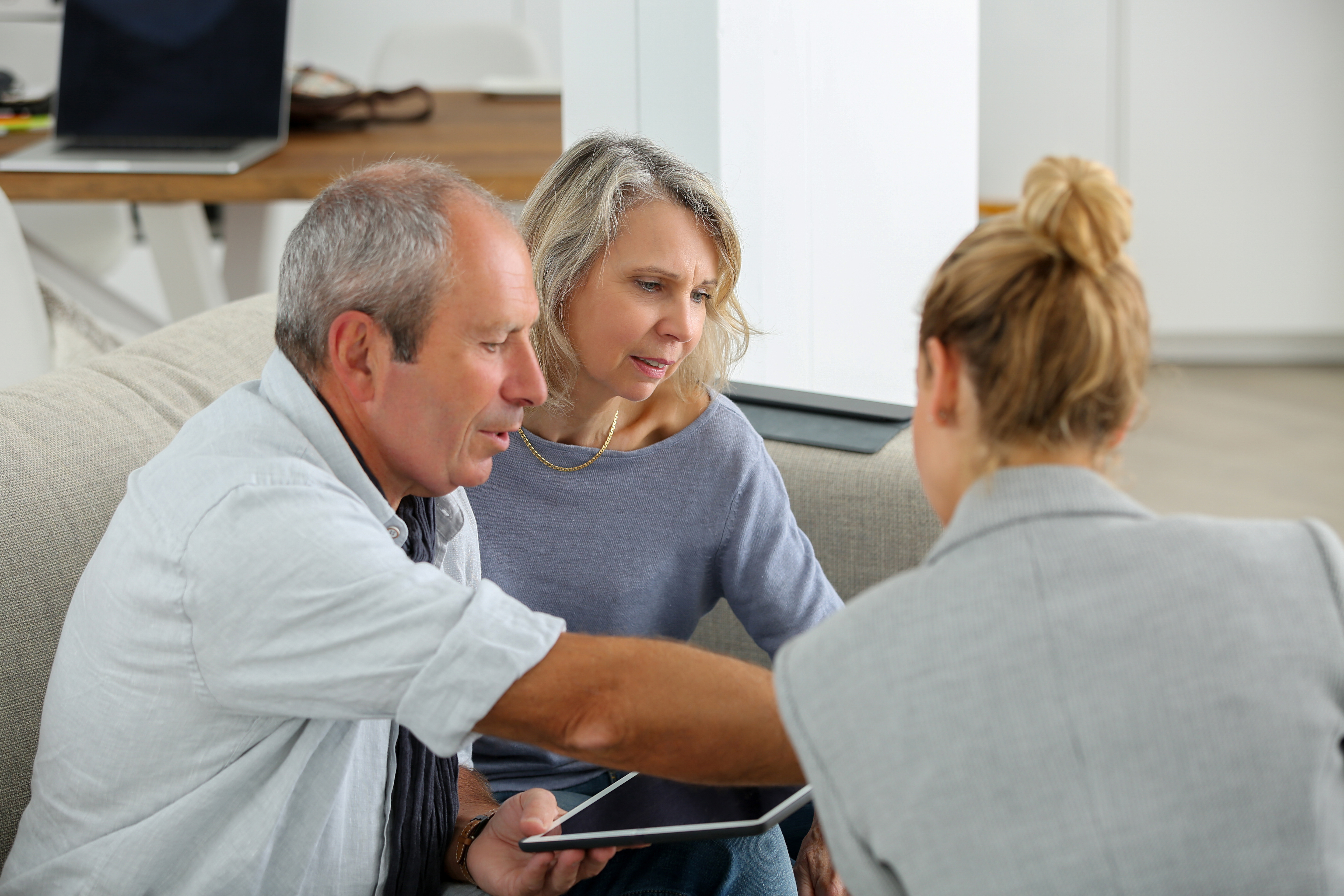 Elderly couple discussing their mortgage with a financial advisor.
